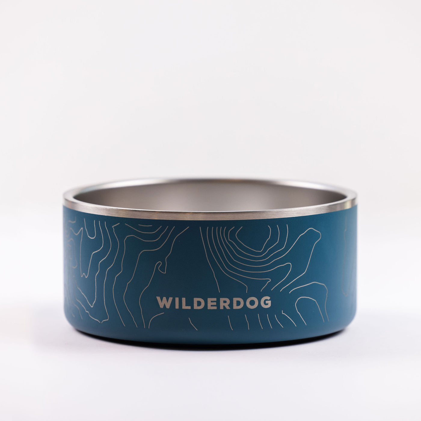 A Stainless Steel Dog Bowl that is BPA-free, showcasing a blue exterior adorned with a topographic map design and the WILDERDOG brand name printed on the side. The interior of the bowl is metallic silver, and it sits on a plain white surface with a minimalistic design.