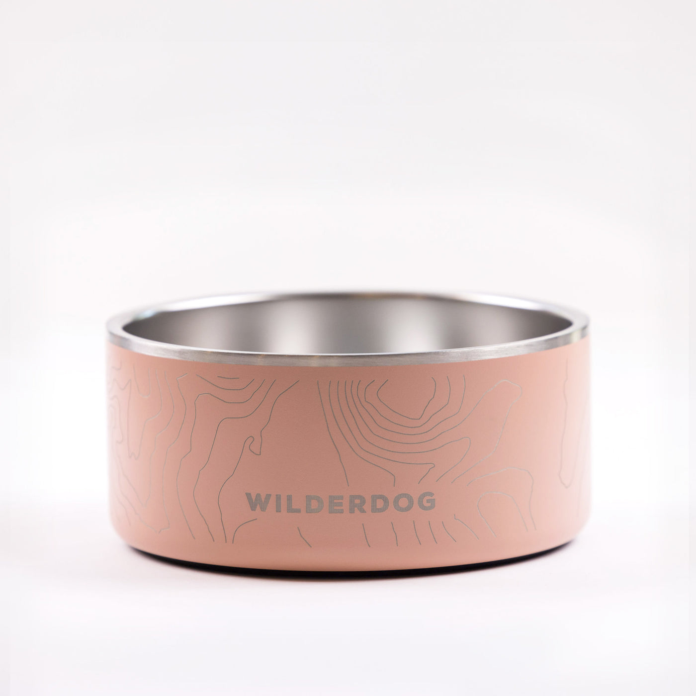 The Stainless Steel Dog Bowl is a robust and stylish option for your pet, featuring a charming light pink exterior adorned with delicate topographic lines. The side of the bowl prominently showcases the "WILDERDOG" brand name in bold capital letters. The background is set against a simple, light gray backdrop.