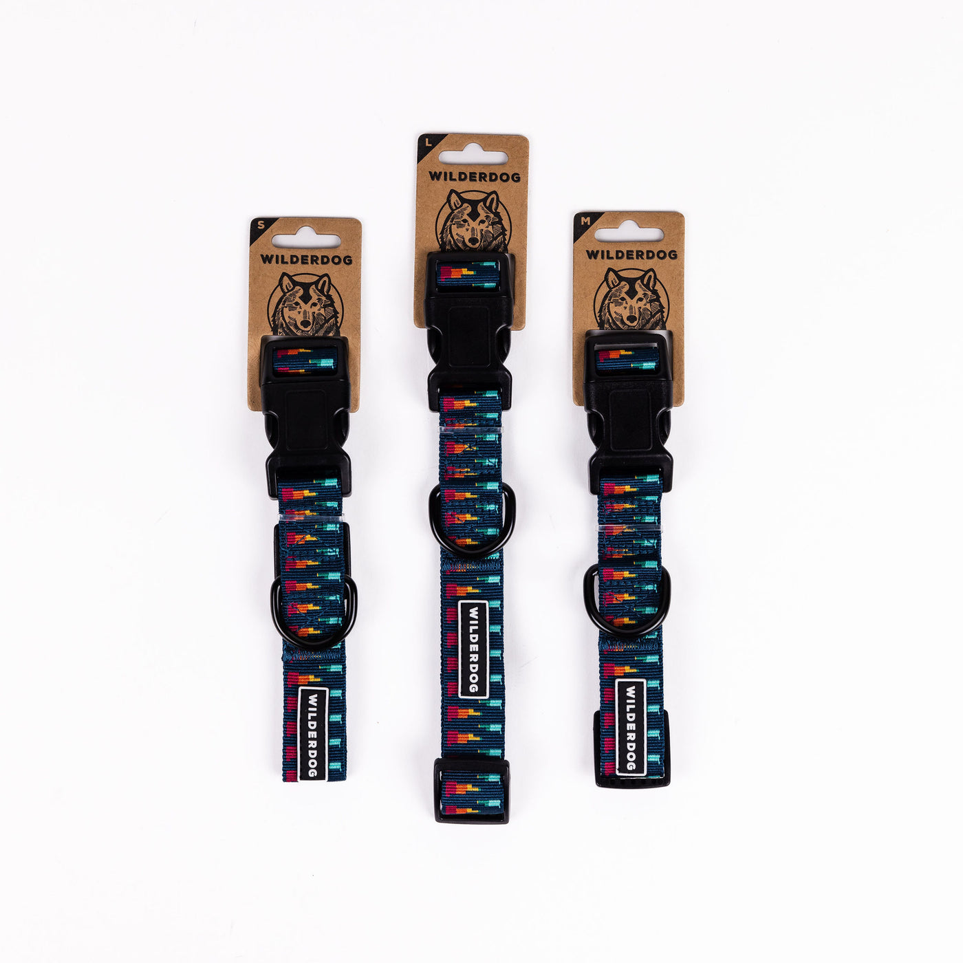 Three Marina Ultralight Collars from Wilderdog's Ultralight Collection are displayed against a white background. Each collar features a colorful pattern with blue, red, yellow, and green hues. The ultralight nylon webbing collars are mounted on kraft paper cards featuring the brand name "WILDERDOG" and a dog's face logo.