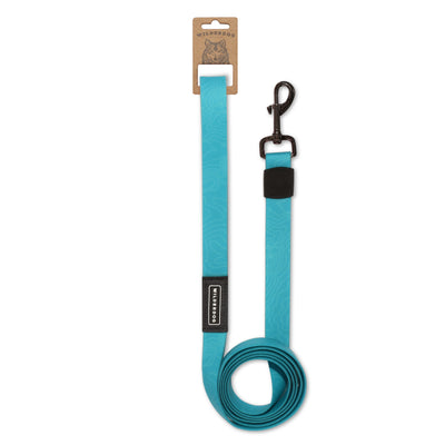 The Teal Waterproof Leash by Wilderdog is a durable, bright turquoise dog leash featuring a subtle abstract pattern and a robust black clip at the end. It includes a small black label displaying the brand name "Wilderdog" and is neatly rolled for presentation. A brown paper tag with a dog illustration adorns the top.